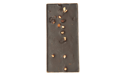 Bar of milk chocolate with raisins and dried apricots on a background of cinnamon sticks close-up