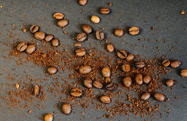 Coffee beans and ground coffee beans on a black background in warm tone