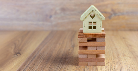 real estate concept, ecological wooden home , model house on top of stack of planks