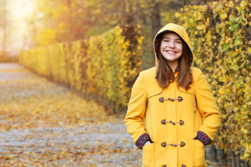 teenage girl in a yellow hooded coat in Augarten park autumn season Vienna Austria