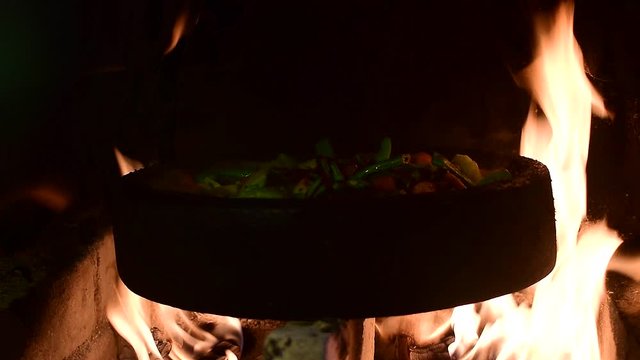 Vegetables cooking on a sach in the fire 