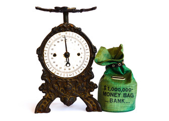 weigh the mo ney saved /weigh the money saved in the piggy-bank with an old black cast-iron balance