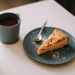 Piece of apple pie on plate with cup of coffee. Breakfast with coffee and cake in cafe. Food photography Table top photo