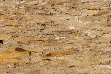Masonry walls made of natural stone, in nature on a summer day, in sunlight.