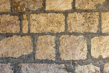 Masonry walls made of natural stone, in nature on a summer day, in sunlight.