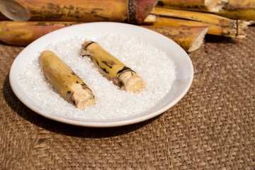 Sugarcane Pieces with Sugar in a Plate on Burlap Fabric with Selective Focus