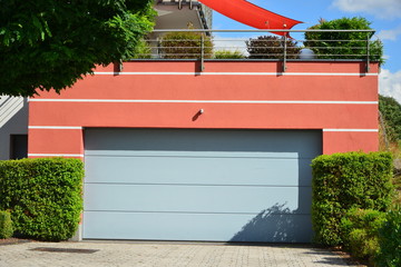 Moderne Beton-Garage mit Automatik-Tor in der Hauszufahrt