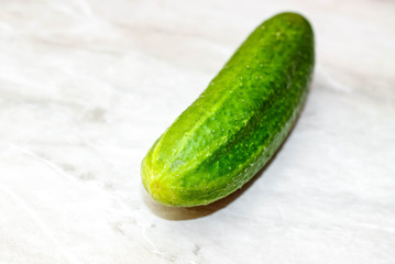 Ripe whole cucumber on a light background.