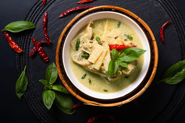 Asian home cooking Concept Thai chicken and baby bamboo Green curry on black background with copy space