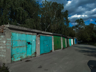 Fototapeta na wymiar Colored garage in the street with trees