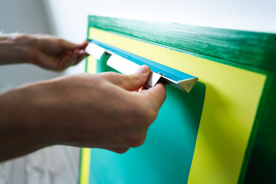 Cropped view of craftsman applying photographic emulsion of frame for screen printing 

