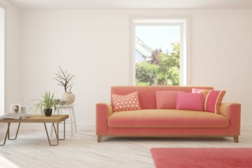 Stylish room in white color with coral sofa and green landscape in window. Scandinavian interior design. 3D illustration