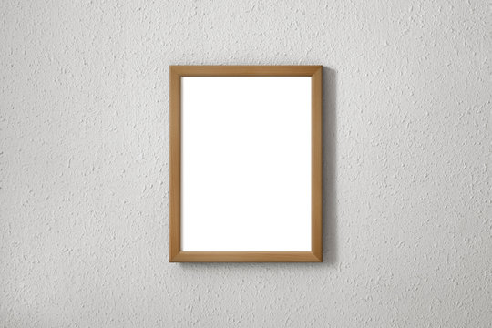 Wooden frame with white background on a textured wall