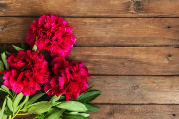 Bright peony flowers on brown wooden table. womans day or wedding background.
