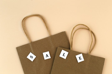 Two paper shopping bags with the words "Sale". Eco-friendly packaging. Retail.
