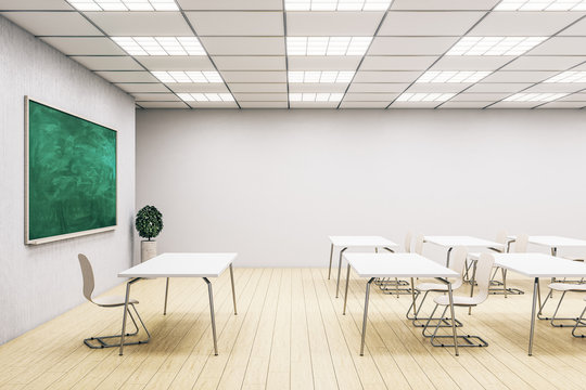 Stylish classroom interior with empty green chalkboard