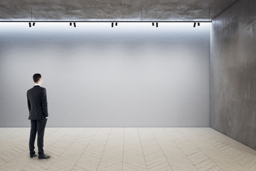 Businessman standing in exhibition hall interior