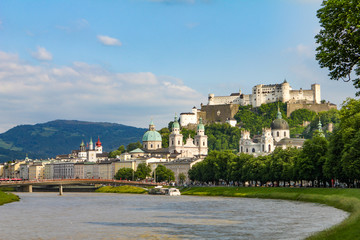 Fototapeta premium Summer landscape of a European city. Mountain river, mountains, church and fortress. Salzburg, Hohensalzburg