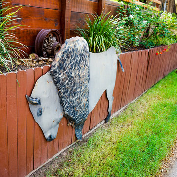 Metal cutout buffalo on wooden fenc