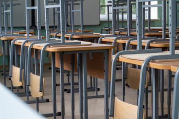 Empty classroom, inverted chairs on desks, distance learning during the pandemic.