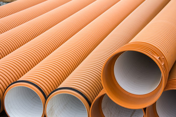 Sewer plastic pipes of orange color at a construction site. Construction Materials. Pipes for water supply