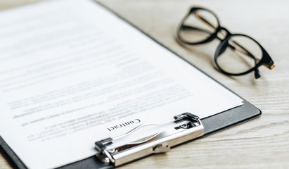 Young girl office worker or business lady signs documents. Concentrated businesswoman working with papers. Business concept