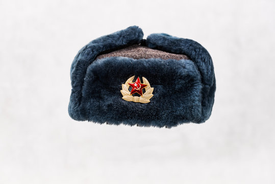 Soviet winter hat with pin badge on light background