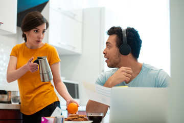 Puzzled woman showing coffee pot to her boyfriend