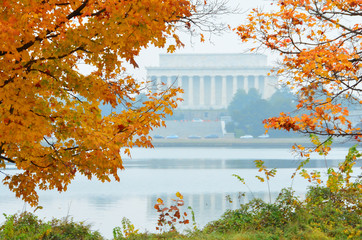 Autumn foliage and Washington D.C. - Lincoln memorial and Potomac River among autumn maple trees.