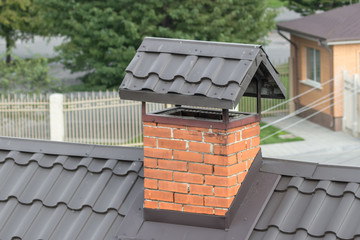 Brick chimney on the roof. Private residential building. Slate covering. Fireplace in the house....