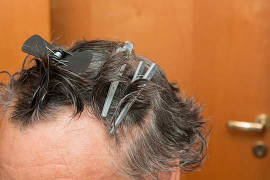 Senior Man With Hair Clips In His Hair Getting A Haircut At Home