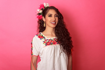 Mexicana sonriendo en blusa típica folclórica de flores con adorno en el cabello
