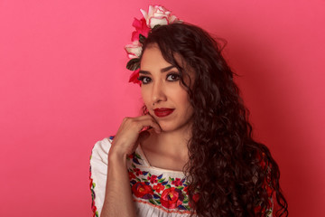 Primer plano de Mexicana latina joven en blusa típica folclórica de flores con adorno en el cabello