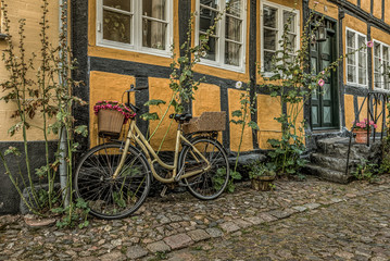 yellow bike leaning against a yellow half-timbered wall
