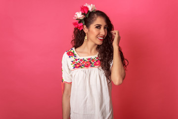 Retrato de hermosa mujer mexicana latina en ropa típica con fondo rosa