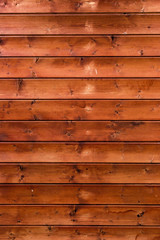 Obraz premium Wooden background for interiors and modern design ideas Treated wooden boards - wood decking flooring and wood deck with paneled walls. Textures and patterns of natural wood. Old brown facade