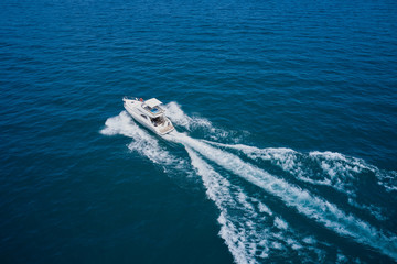 Motor boat in the sea.Travel - image. Aerial bird's eye view photo taken by drone of boat. Top view of a white boat sailing to the blue sea.