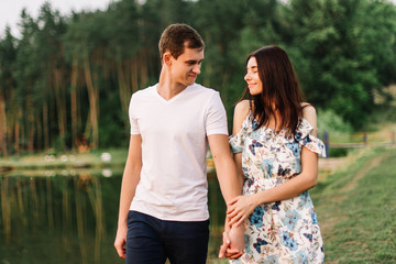 Obraz premium Young loving couple hugging near lake on sunset.