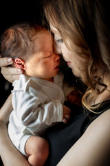 Close up portrait of beautiful young mother with newborn baby on black background , copy space. Healthcare and medical love lifestyle mother