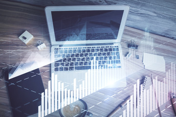 Double exposure of financial chart drawing over table background with computer. Concept of research and analysis. Top view.