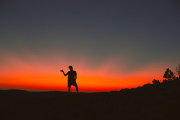 Silhouette of a man standing on a mountain top