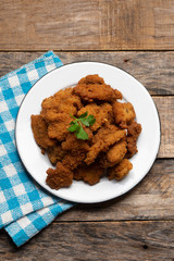 Fish chicharron with mayonnaise and onion on wooden background