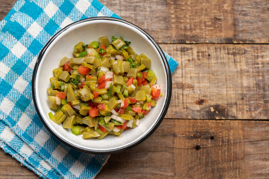 Mexican nopal cactus salad on wooden background