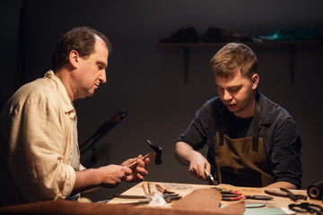 a father-shoemaker passes on to his son the experience of hand-making shoes in his workshop