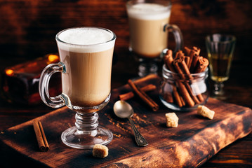 Irish coffee with cinnamon on wooden surface