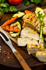 Grilled Chicken Breasts with Grilled Vegetables Zucchini and Carrot Background. Selective focus.