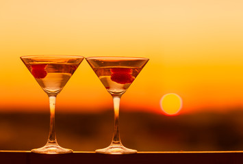Martini drink at golden sunset background. Night life concept.