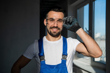 Man in overalls and goggles looking at the camera and smiling