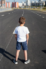 boy is standing on  road, safety of children on the roadway, traffic rules concept, deadly threat
