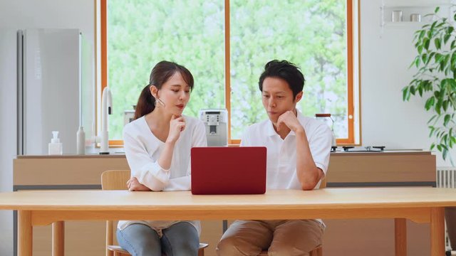 部屋ででパソコンを使うカップル